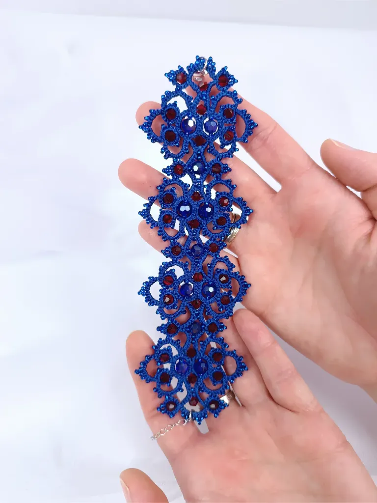 Brazalete azul eléctrico con cristales rojo oscuro. Fabricado en Tarragona, artesanal y personalizable..webp