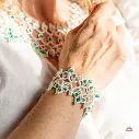 Brazalete ultraligero nupcial con cristales color esmeralda y perlas blancas.